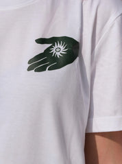 White t-shirt with a black and green hand graphic and symbol on the chest.