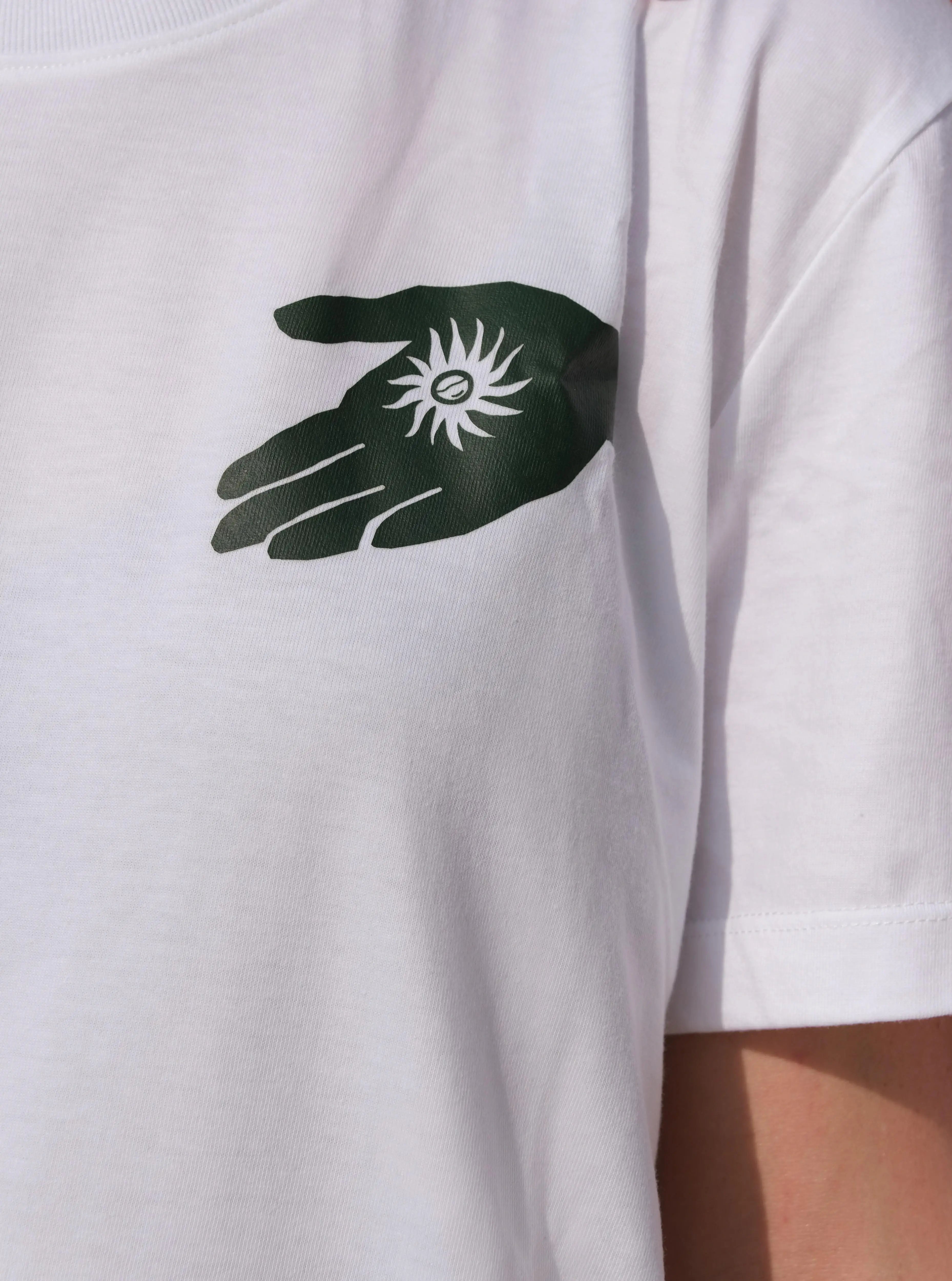 White t-shirt with a black and green hand graphic and symbol on the chest.