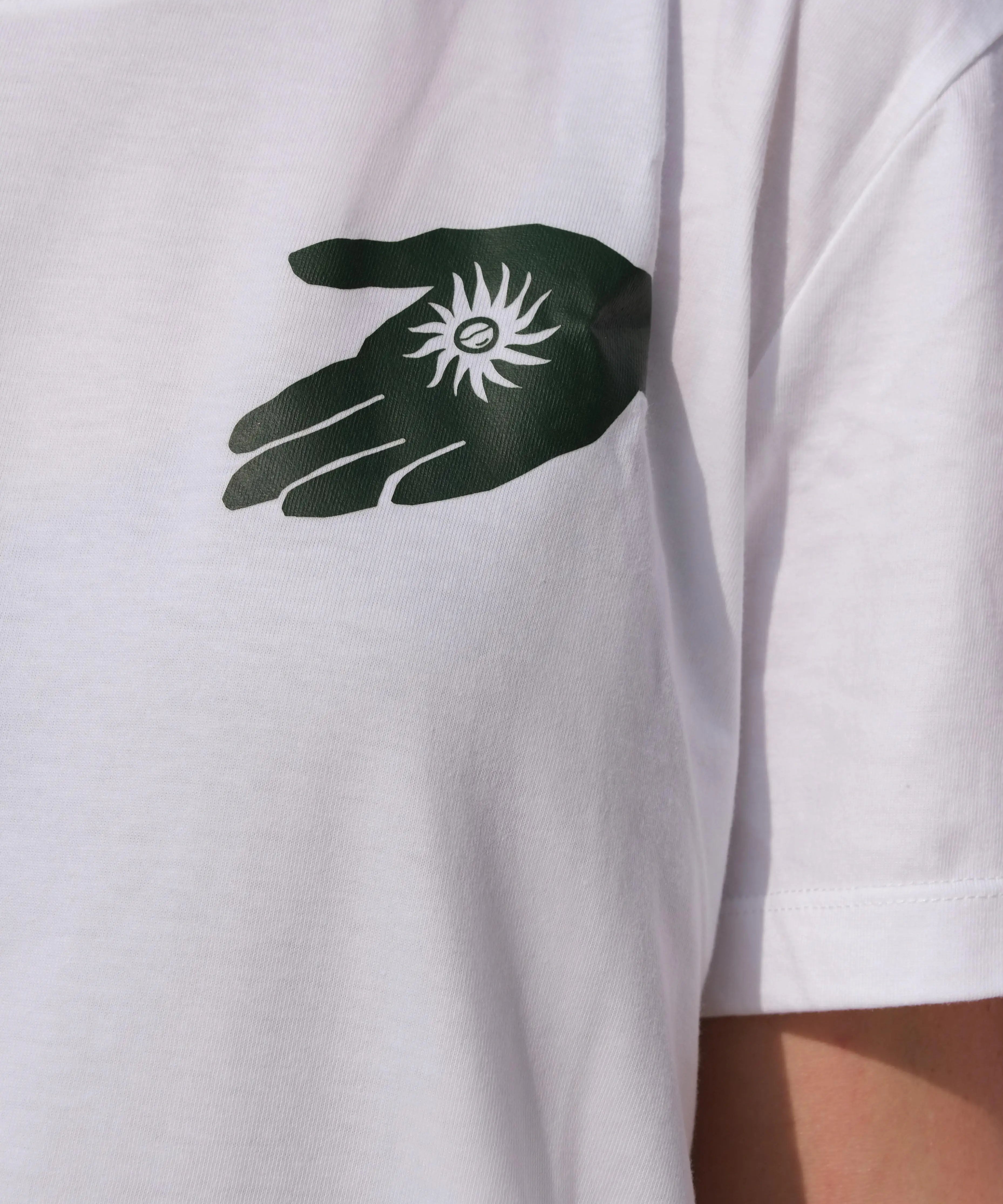 White t-shirt with a black and green hand graphic and symbol on the chest.